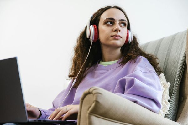 Person sitting calmly in a bright room, focusing forward.